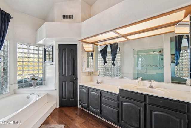 bathroom with independent shower and bath, vanity, and hardwood / wood-style flooring