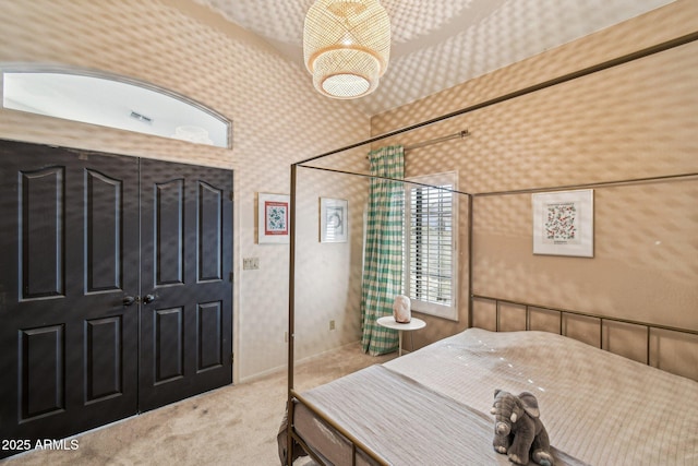 bedroom featuring light carpet and wallpapered walls