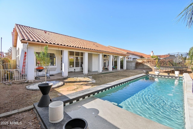 view of swimming pool with a trampoline and a patio area