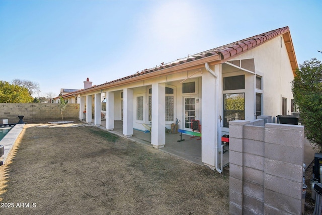 back of house with a patio, fence, and stucco siding