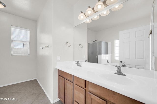 full bath featuring a sink, baseboards, tile patterned floors, double vanity, and a stall shower