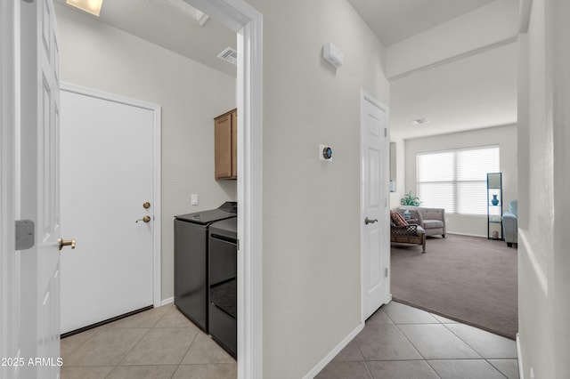 hallway with washer and clothes dryer, light tile patterned floors, visible vents, light carpet, and baseboards