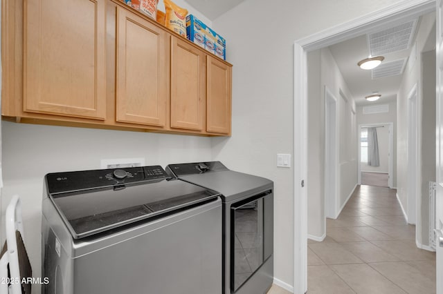 washroom featuring visible vents, cabinet space, washer and clothes dryer, and light tile patterned floors