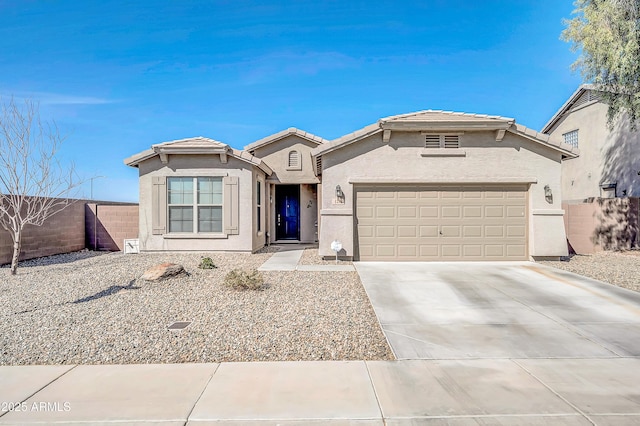 view of front facade with fence, driveway, stucco siding, a garage, and a tile roof