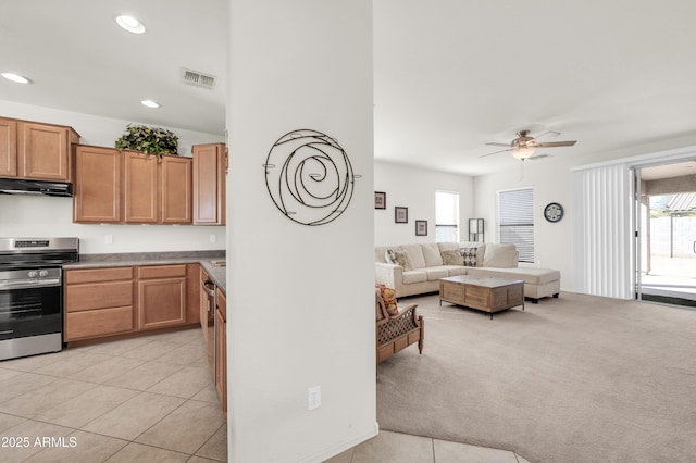 kitchen featuring light colored carpet, under cabinet range hood, visible vents, appliances with stainless steel finishes, and a wealth of natural light