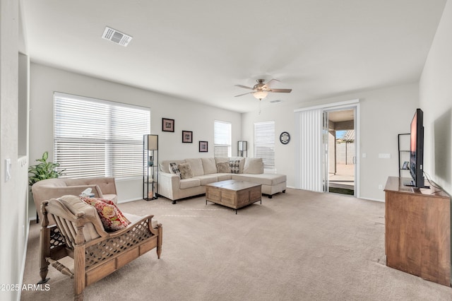 living area featuring a ceiling fan, visible vents, and light colored carpet