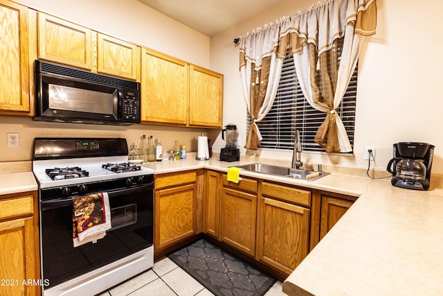 kitchen with gas stove, sink, and light tile patterned flooring