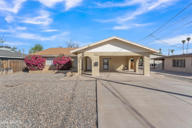 ranch-style house with brick siding, concrete driveway, and fence