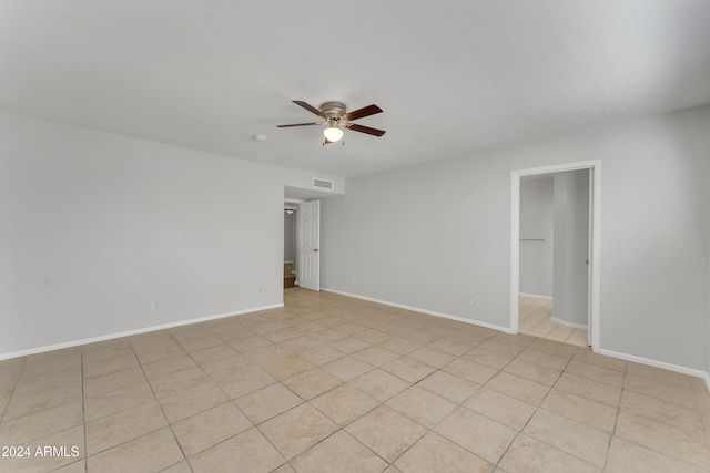 spare room featuring light tile patterned flooring, baseboards, visible vents, and ceiling fan