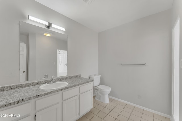 bathroom with toilet, vanity, and tile patterned flooring