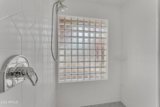 interior details featuring a tile shower