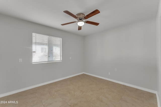 empty room with a ceiling fan and baseboards