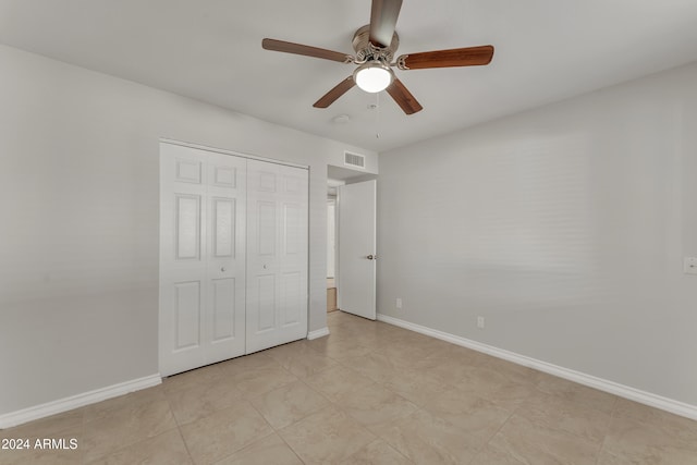 unfurnished bedroom featuring a closet, baseboards, visible vents, and ceiling fan