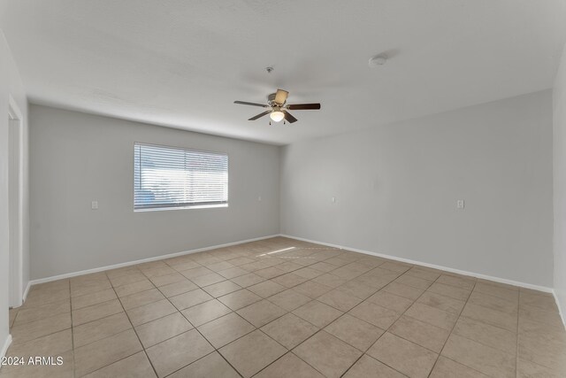 tiled empty room featuring ceiling fan