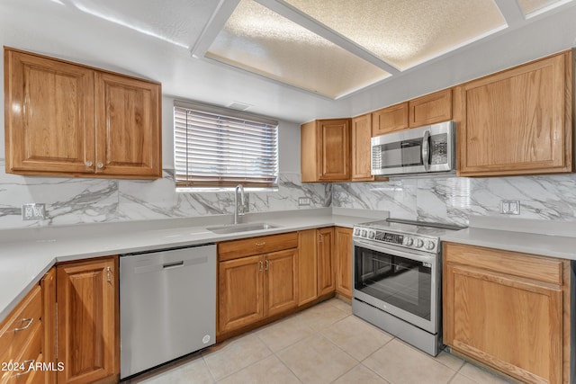 kitchen with sink, stainless steel appliances, light tile patterned floors, and tasteful backsplash