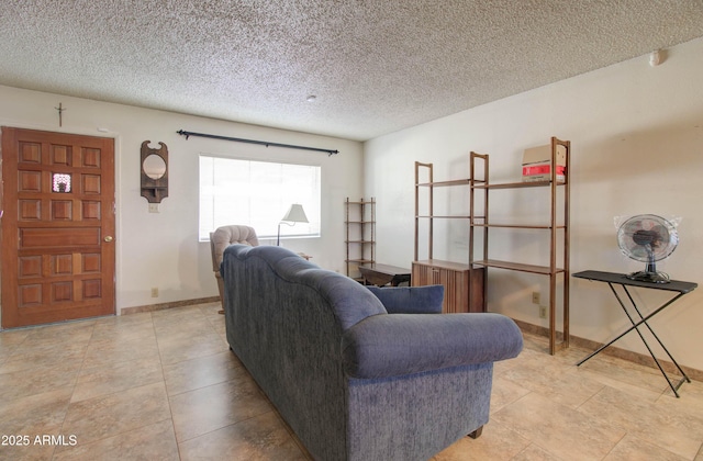 living room featuring baseboards, light tile patterned floors, and a textured ceiling