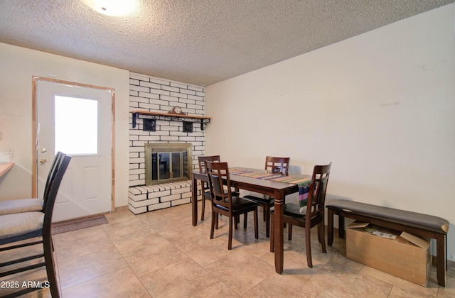 dining room with a brick fireplace and a textured ceiling