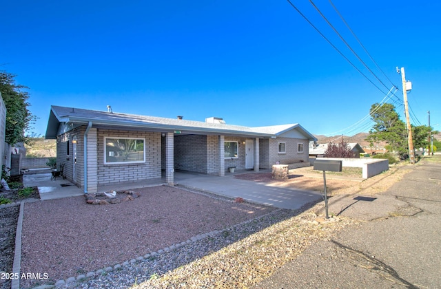 ranch-style house with brick siding and a patio area