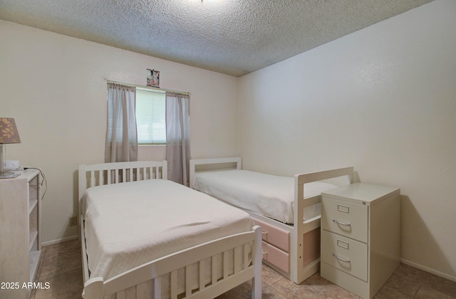 bedroom with a textured ceiling and baseboards