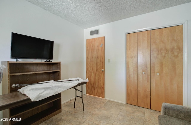 interior space with a textured ceiling and visible vents