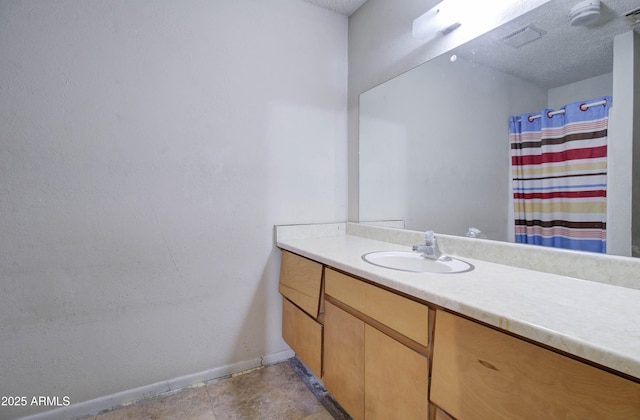 bathroom with a textured ceiling, vanity, a shower with curtain, and baseboards