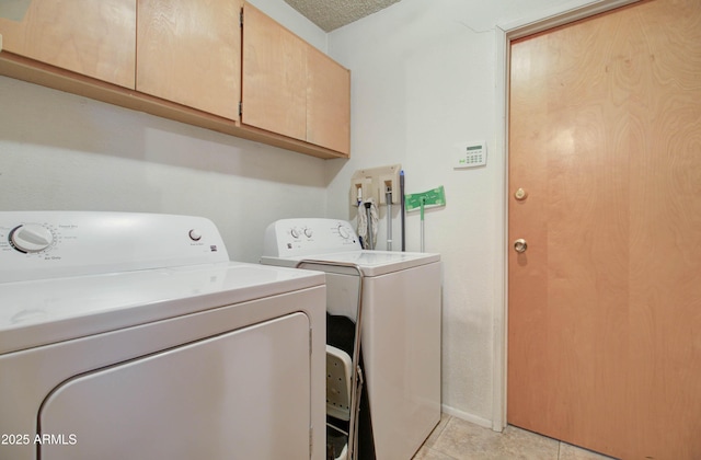 laundry room with washing machine and dryer, light tile patterned flooring, and cabinet space