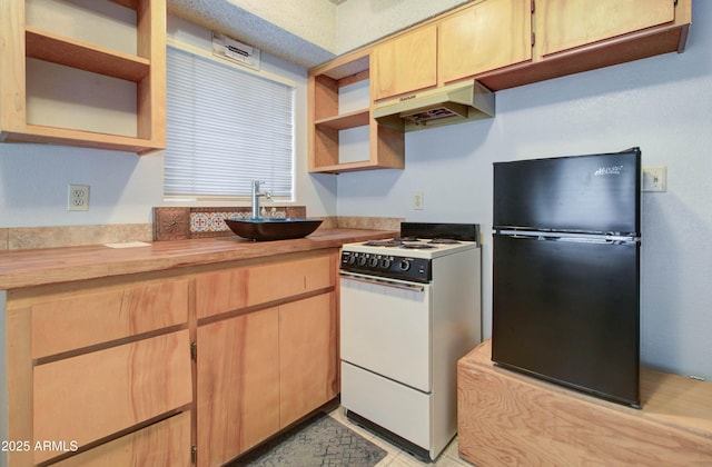 kitchen featuring white gas range, open shelves, under cabinet range hood, and freestanding refrigerator