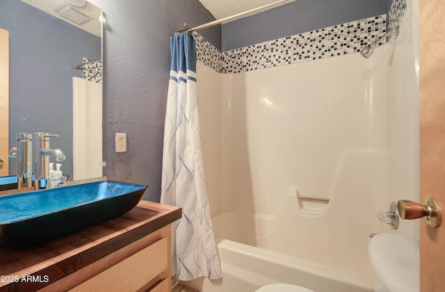 full bathroom with toilet, a textured wall, vanity, and shower / bath combination with curtain