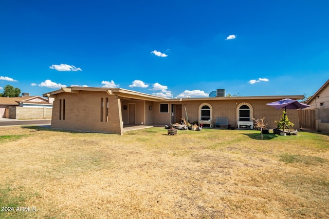 back of property with a yard, a patio, and fence