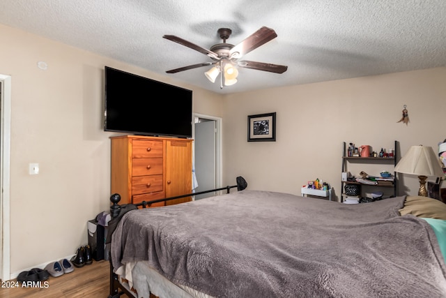 bedroom featuring ceiling fan, a textured ceiling, and wood finished floors