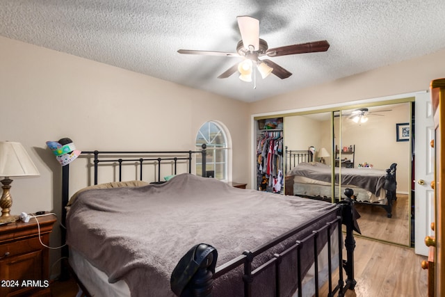 bedroom with a closet, ceiling fan, a textured ceiling, and wood finished floors