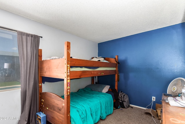 carpeted bedroom with a textured ceiling and baseboards