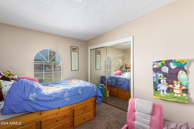 bedroom with a textured ceiling, carpet floors, and a closet