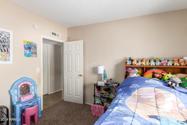 bedroom featuring carpet, visible vents, and a textured ceiling