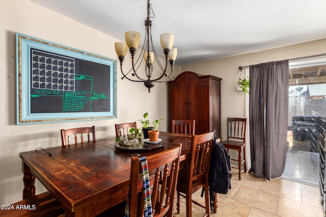 dining space featuring a textured ceiling, light tile patterned flooring, and a notable chandelier