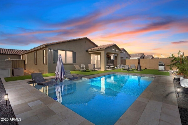 view of swimming pool featuring a patio area, a fenced backyard, and a fenced in pool