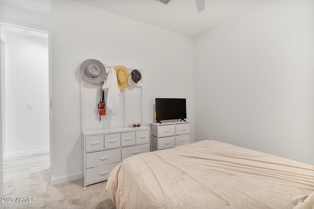 bedroom with ceiling fan, baseboards, and light colored carpet