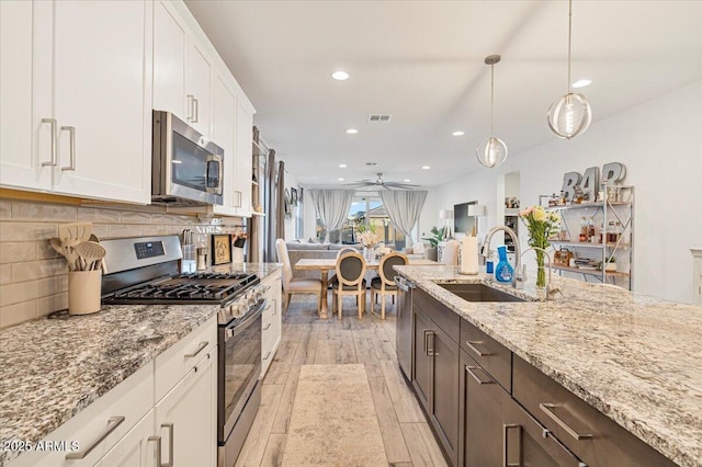 kitchen with stainless steel appliances, a sink, visible vents, recessed lighting, and white cabinetry