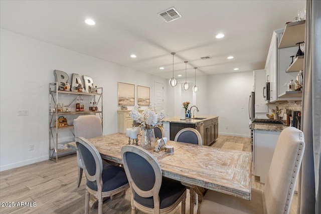 dining area featuring baseboards, light wood-style flooring, visible vents, and recessed lighting