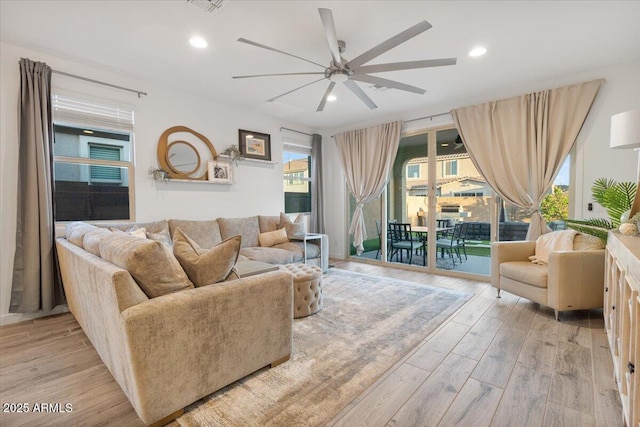living area featuring light wood-type flooring, a ceiling fan, and recessed lighting