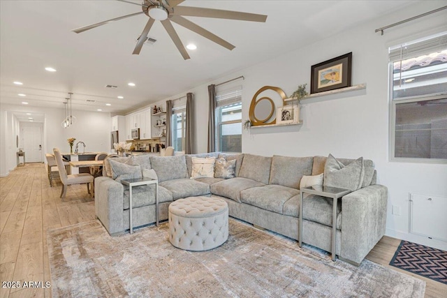 living area with a ceiling fan, light wood-style floors, visible vents, and recessed lighting
