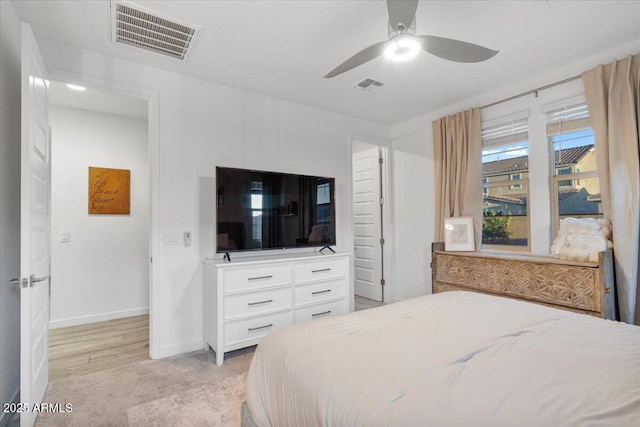 bedroom with light colored carpet, baseboards, a ceiling fan, and visible vents