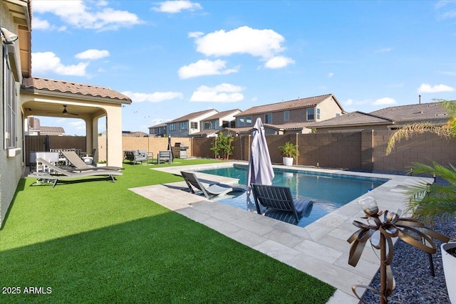 view of swimming pool with a lawn, a fenced backyard, a fenced in pool, a patio, and a residential view