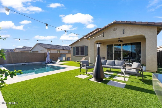 back of property with a fenced backyard, a yard, ceiling fan, a patio area, and an outdoor living space