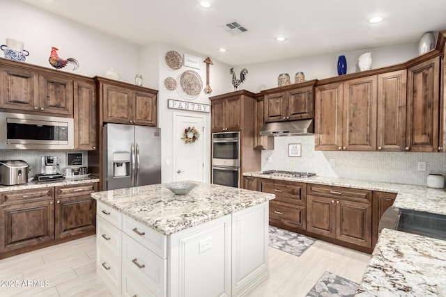 42711 N 45th Dr, Phoenix, AZ 85087 - kitchen with decorative backsplash, visible vents, light stone counters, under cabinet range hood, and stainless steel appliances