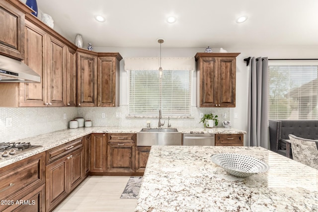 42711 N 45th Dr, Phoenix, AZ 85087 - kitchen featuring light stone countertops, a sink, appliances with stainless steel finishes, backsplash, and hanging light fixtures