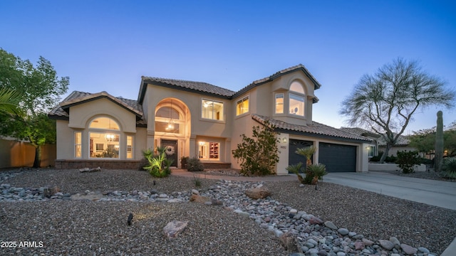 mediterranean / spanish-style home featuring concrete driveway, a tile roof, and stucco siding