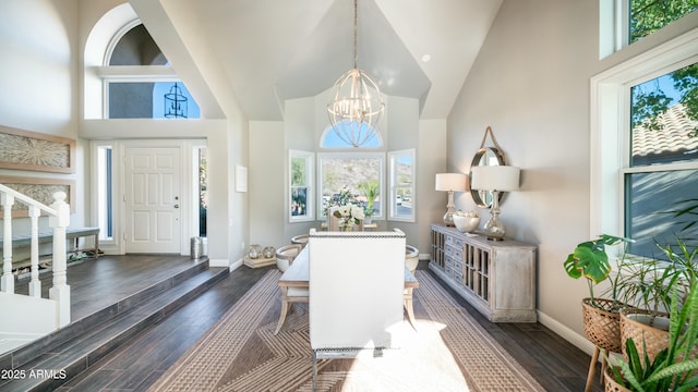 foyer with baseboards, high vaulted ceiling, dark wood-type flooring, and a notable chandelier