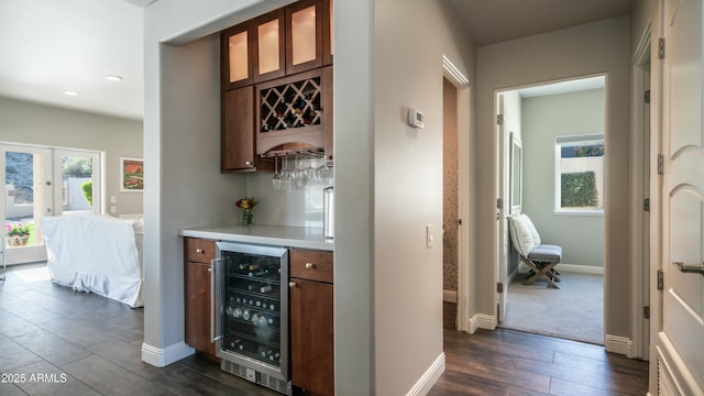 bar featuring wine cooler, dark wood-style flooring, baseboards, french doors, and a dry bar