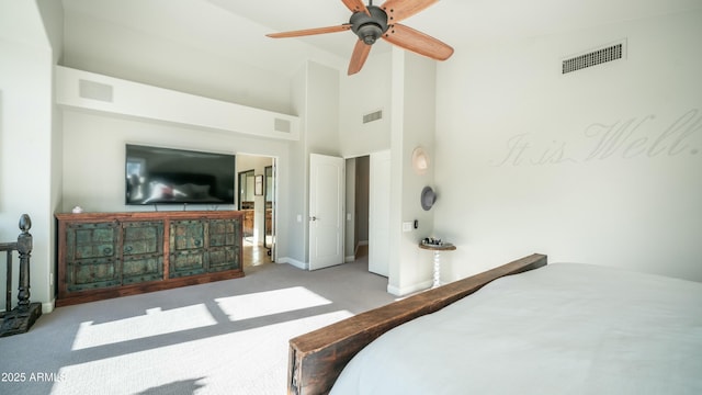 bedroom featuring visible vents, light carpet, and a towering ceiling